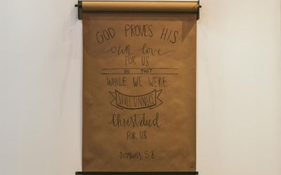 Scroll displaying Romans 5:8 to illustrate the article Hate the Sin and Love the Sinner?